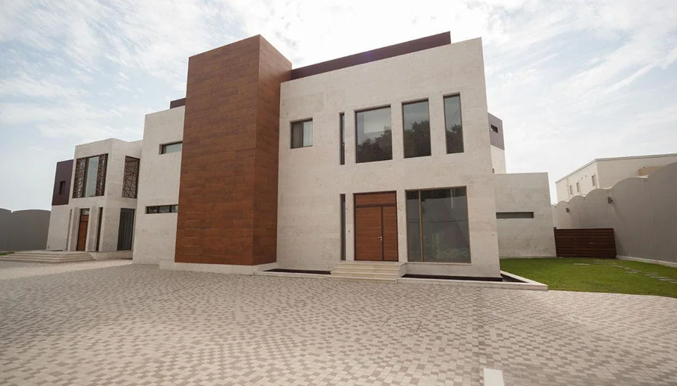 واجهة فيلا سكنية بتكسيات حجرية وخشبية — من أعمال SDC Construction