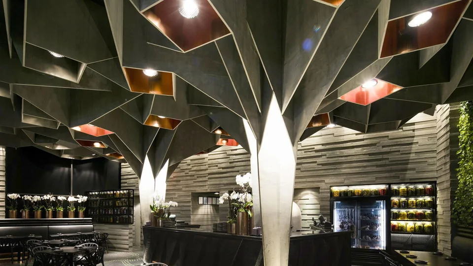 مطعم بسقف معماري وأعمدة منحوتة وإضاءة دافئة — من أعمال SDC Construction